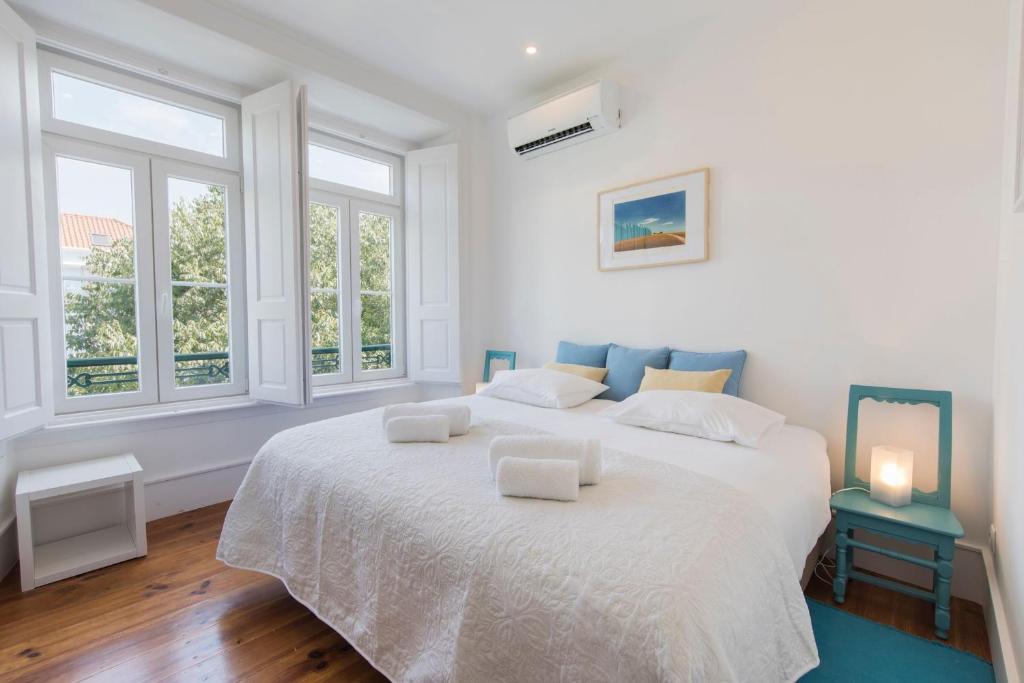 リスボンにあるLovelyStay - Comfortable apartment with river viewsの白いベッドルーム(大きな白いベッド1台、椅子2脚付)