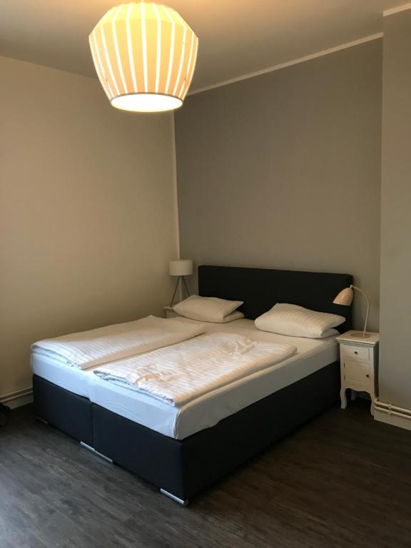una camera da letto con un grande letto con una luce sopra di Hotel Fame am Hauptbahnhof ad Amburgo
