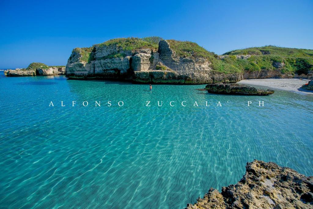 una gran masa de agua con una playa y rocas en Hotel Mare Blu, en Torre dell'Orso