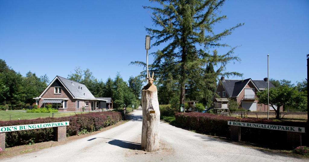 a street sign on a wooden pole in a yard at Bok's Bungalowpark in Garderen