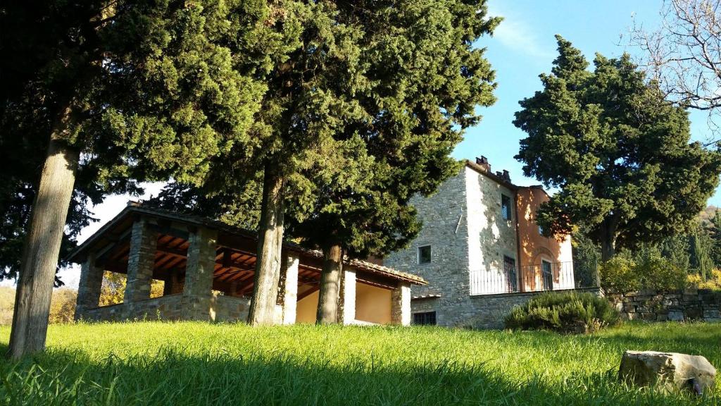 uma grande casa de pedra com árvores em primeiro plano em Florence Country Relais em Fiesole
