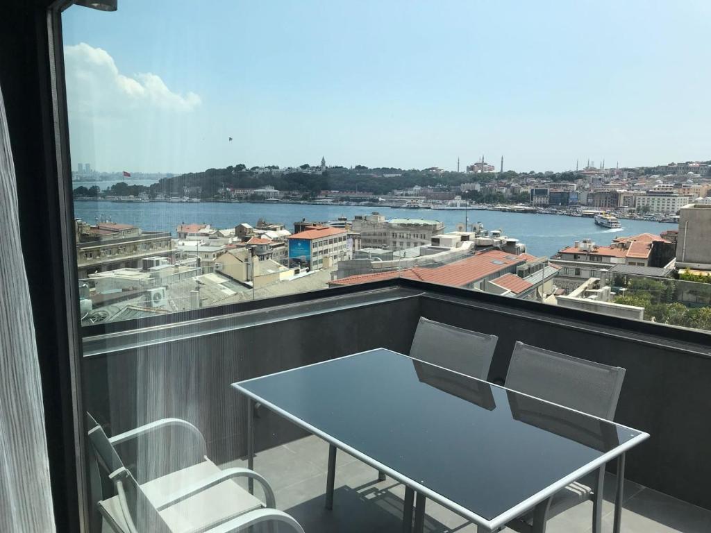 a table and chairs on a balcony with a view of the water at Bankerhan Hotel Galata - Special Category in Istanbul