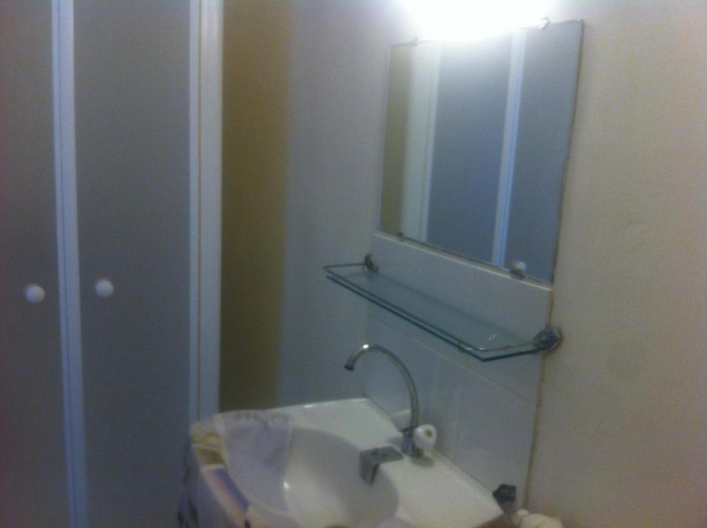 ein Bad mit einem Waschbecken und einem Spiegel in der Unterkunft le flibustier in Granville