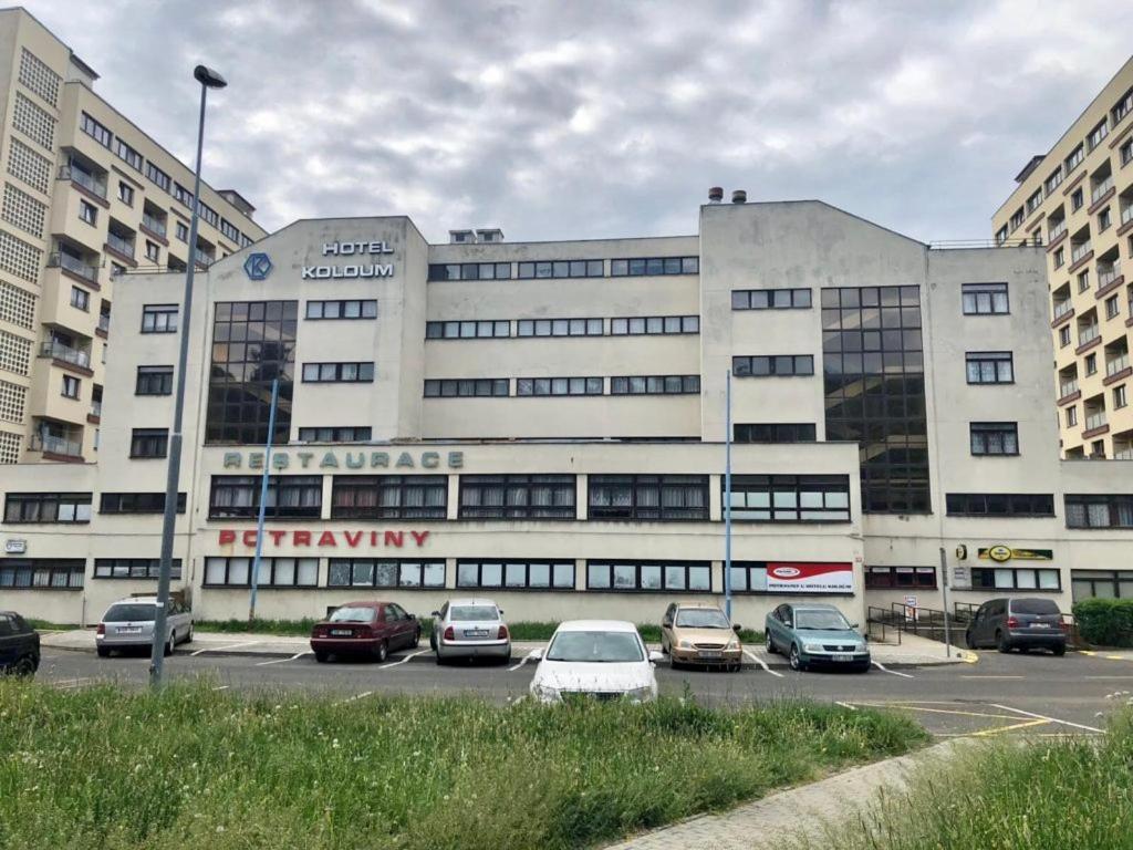 a large building with cars parked in a parking lot at Hotel Koldum in Litvínov