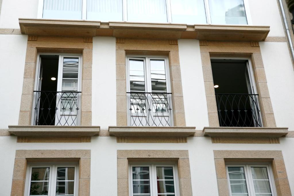 ルーゴにあるapartamento centro calle reinaの窓とバルコニー付きの建物の外観