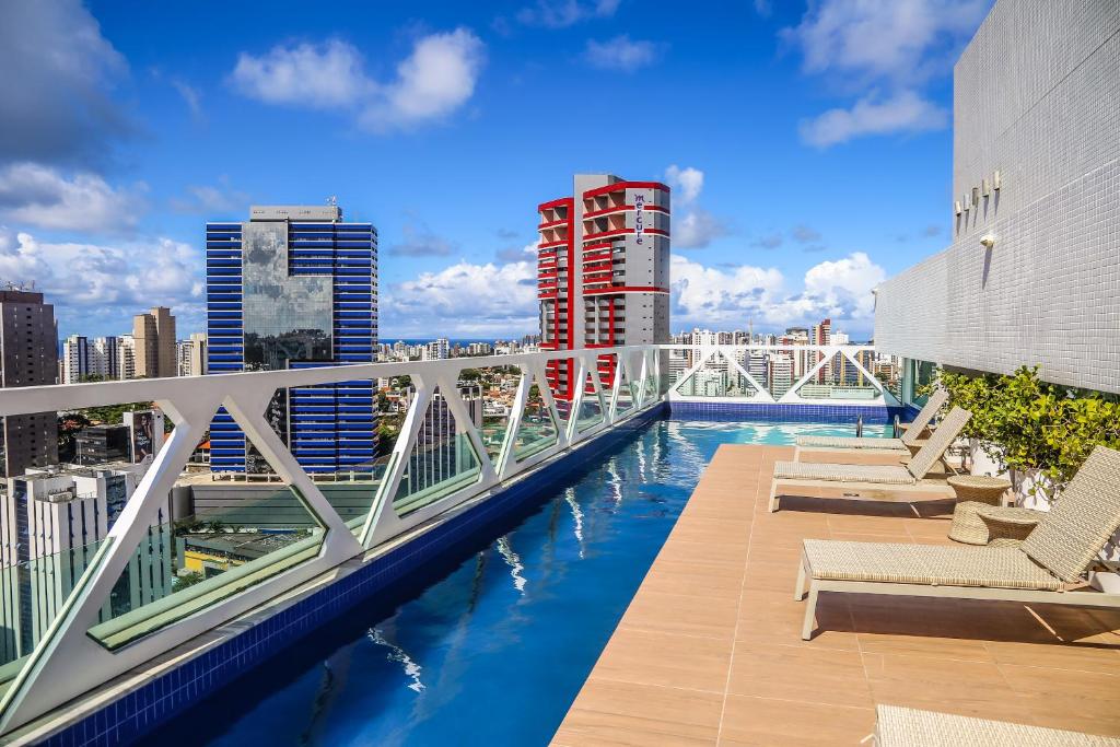 a swimming pool on the roof of a building with buildings at Salvador Business & Flat by Avectur in Salvador