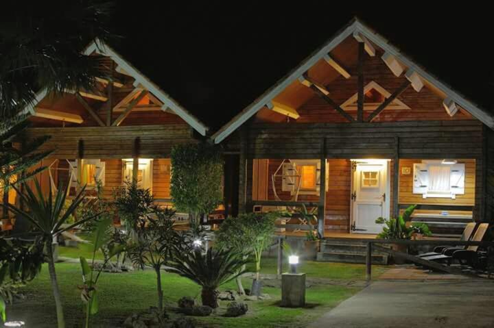 une maison en bois avec une terrasse couverte à l'avant la nuit dans l'établissement Kitecamp Tarifa, à Tarifa