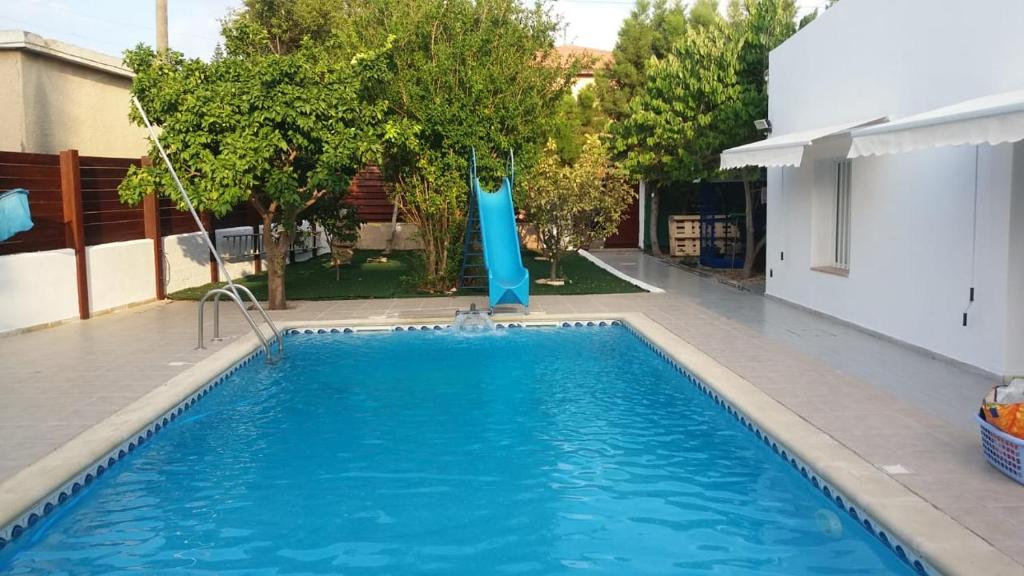 a swimming pool with a blue slide in a backyard at Alekas Pool and Garden Home in Paphos