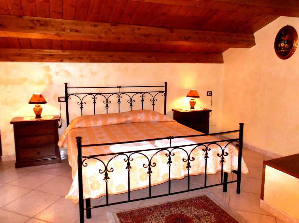 a bedroom with a black bed with two night stands at Dolcedorme Bed And Breakfast in Terranova di Pollino