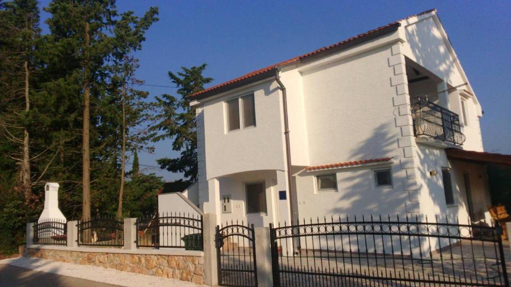 uma casa branca com uma cerca à frente. em Tajči em Ugljan