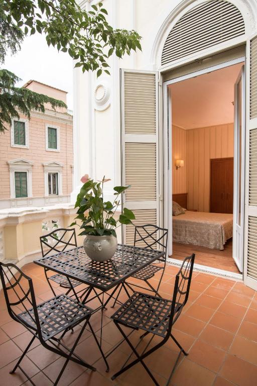 a table with chairs and a potted plant on a patio at Hotel Villa Delle Rose in Rome