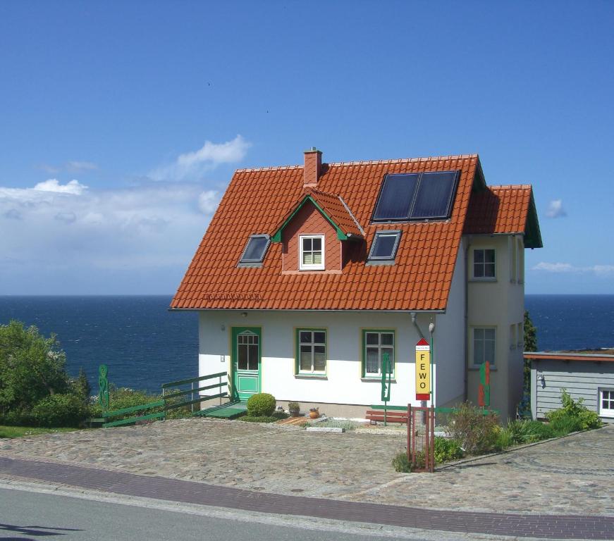 ein Haus mit einem orangenen Dach und dem Meer in der Unterkunft Über dem Meer in Lohme