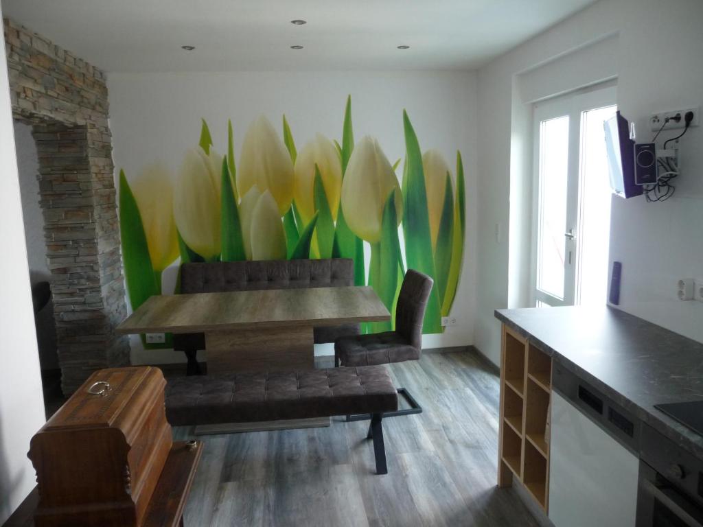 een kamer met een tafel en een stel tulpen aan de muur bij Harzurlaub in Blankenburg