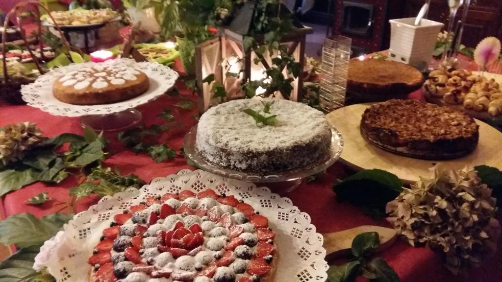 a table topped with cakes and pies on plates at hotel Bologna in Fanano