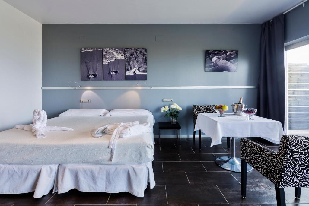 a bedroom with two beds and a table and chairs at Mazagonia in Mazagón