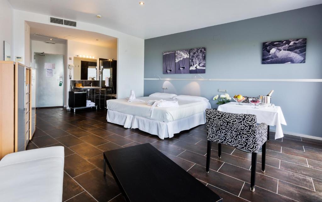 a hotel room with two beds and a table and chairs at Mazagonia in Mazagón