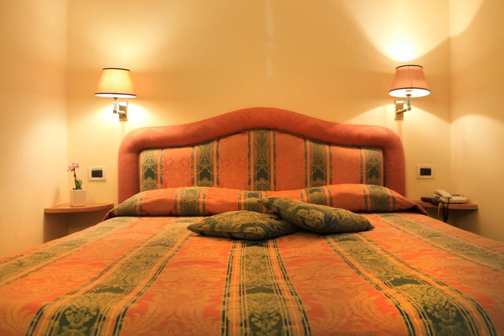 a bedroom with a large bed with two pillows on it at Hotel Villa Delle Rose in Rome
