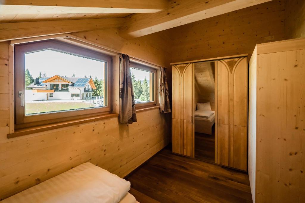 mały pokój z oknem w drewnianym domku w obiekcie Camping Chalet Salten w mieście Jenesien