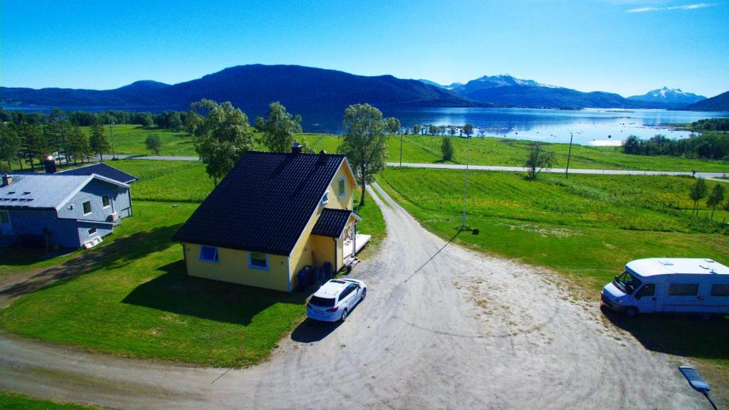 an aerial view of a house with a car parked in a driveway at 1 Room in The Yellow House, close to Airport & Lofoten in Evenskjer