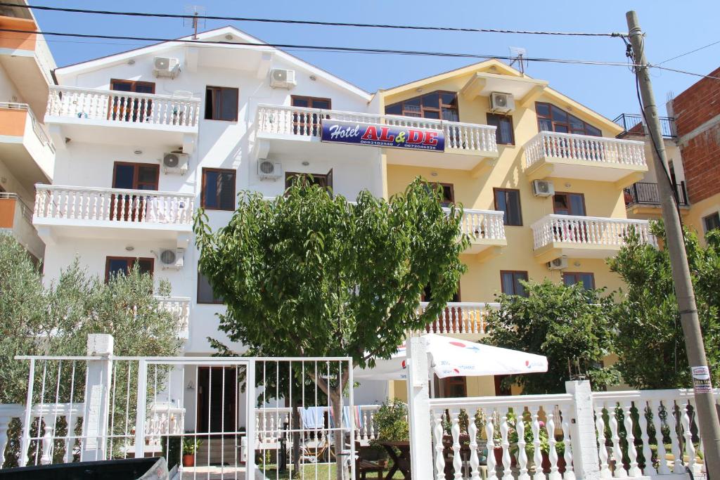un edificio con balcones blancos y una valla blanca en Apartments Hotel AL&DE, en Velipojë