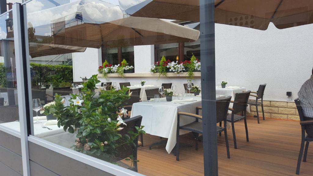 a restaurant with tables and umbrellas on a balcony at Hotel Re'ser Stuff in Roeser