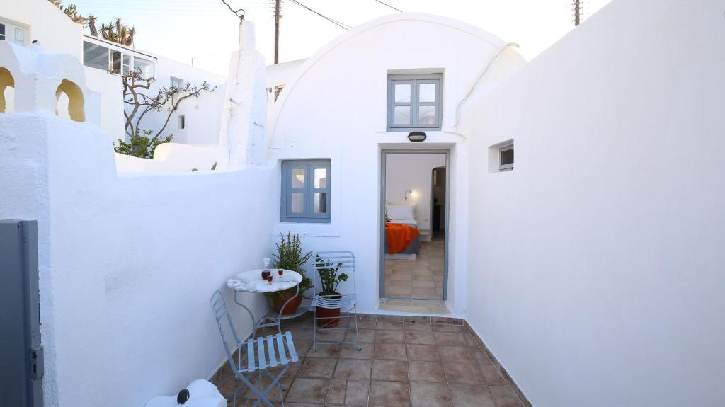 een gang van een wit huis met een boog bij Mylopetres Traditional Houses Finikia in Oia