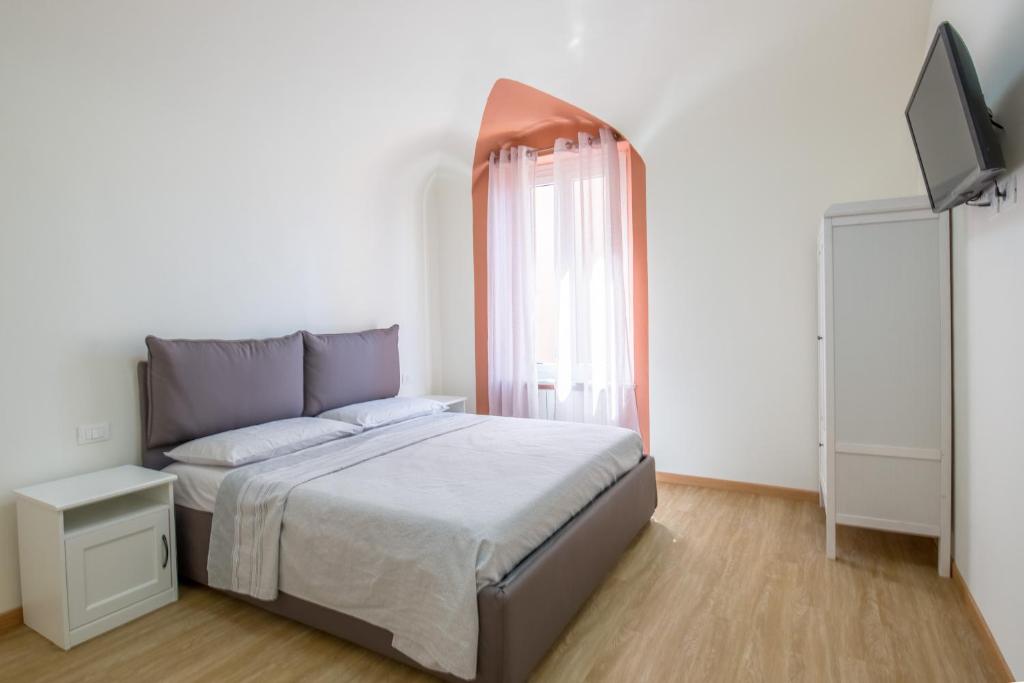 een slaapkamer met een bed en een flatscreen-tv bij La terrazza in Varazze