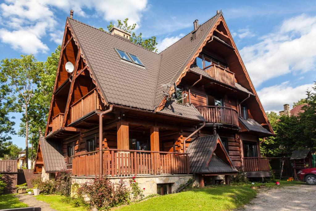 a large wooden house with a gambrel at Willa Mecenasówka in Zakopane