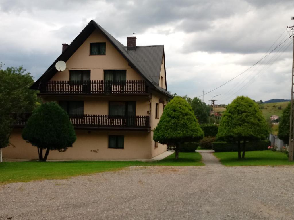 una casa con un balcón en el lateral. en Gazdówka "Pod Pstrągiem", en Korbielów