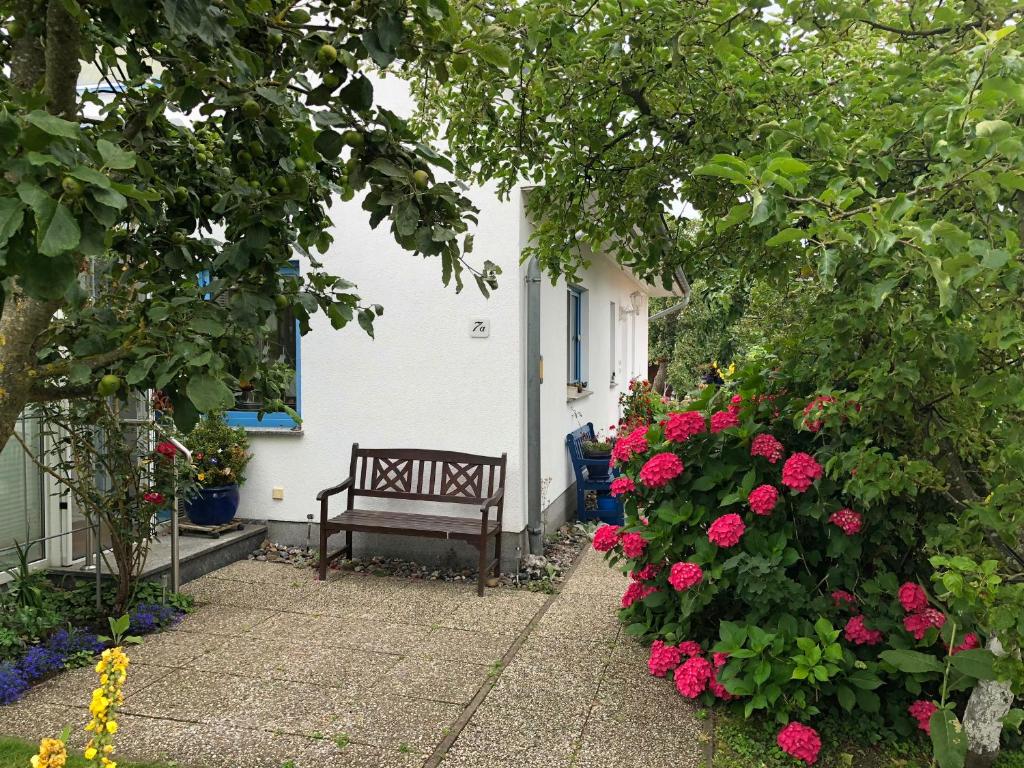 a bench in front of a house with flowers at Ferienwohnung mit Garten in Wieck
