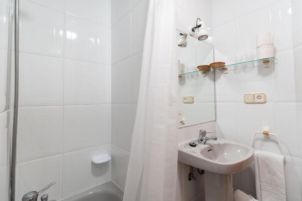 a white bathroom with a sink and a shower at Hotel Panadeiramar in Sanxenxo