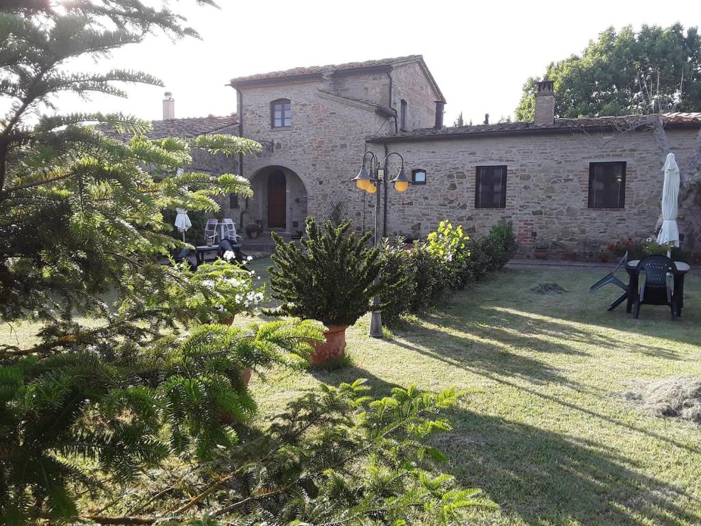 a stone house with a garden in front of it at Agriturismo Podere Molino in Peccioli