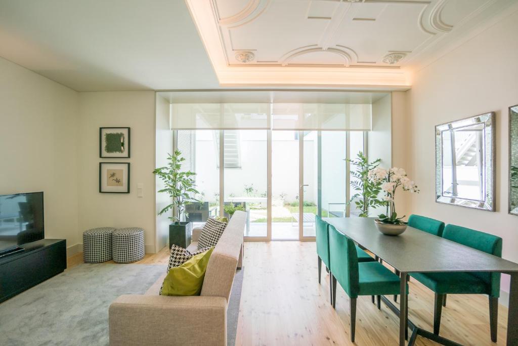リスボンにあるCourtyard & Elegance Apartmentのリビングルーム(テーブル、椅子、テレビ付)
