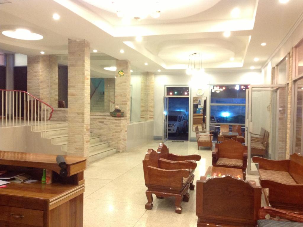 un hall avec des chaises et un escalier dans un bâtiment dans l'établissement Mitaree Hotel 1, à Mae Sariang