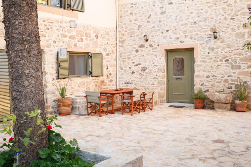 泰帕奇的住宿－Traditional Villa Priotissa，一个带桌椅的庭院和一座建筑