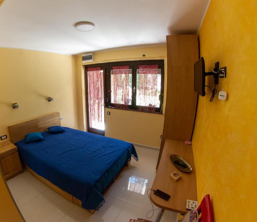 a bedroom with a blue bed and a window at Apartment 9 Gorska Vila in Zlatibor