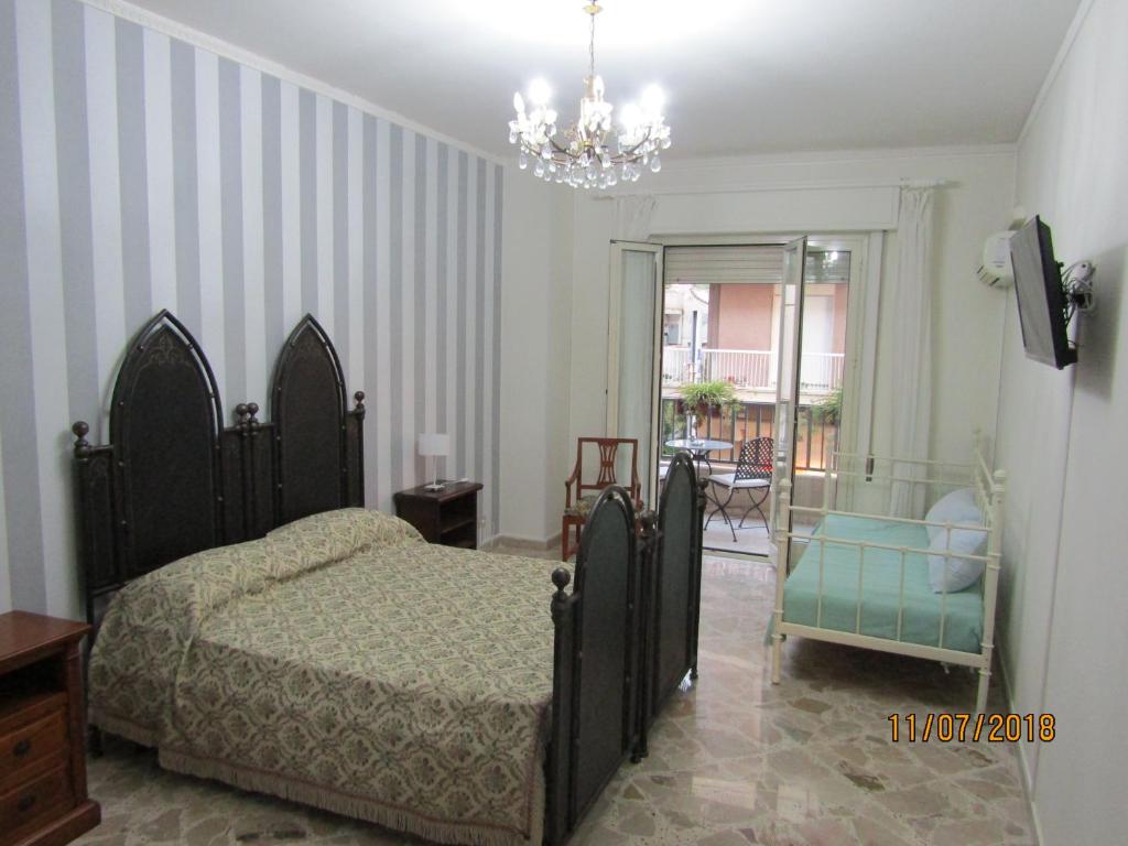 1 dormitorio con cama y lámpara de araña en Tilde B&B en Cefalù