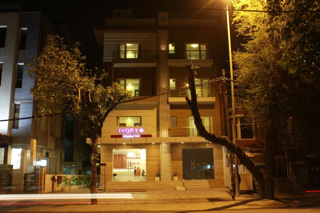 een gebouw met 's nachts een neonbord bij Hotel Ivory 32 in New Delhi