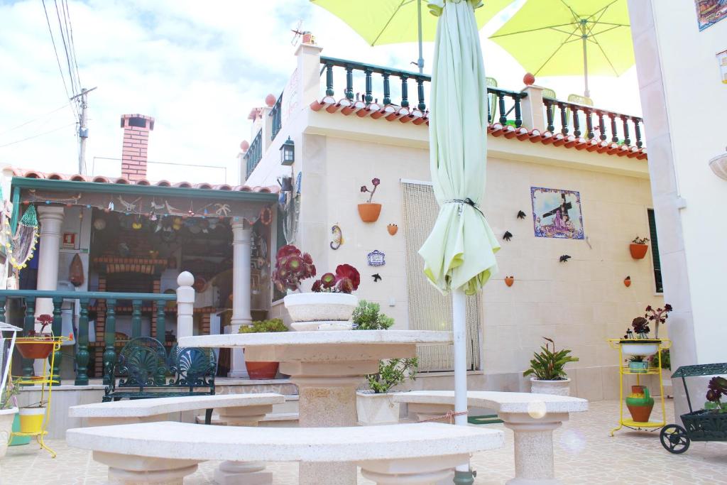 un patio con una fuente y una sombrilla en Moradia Meca - Casas para Férias, en Nazaré