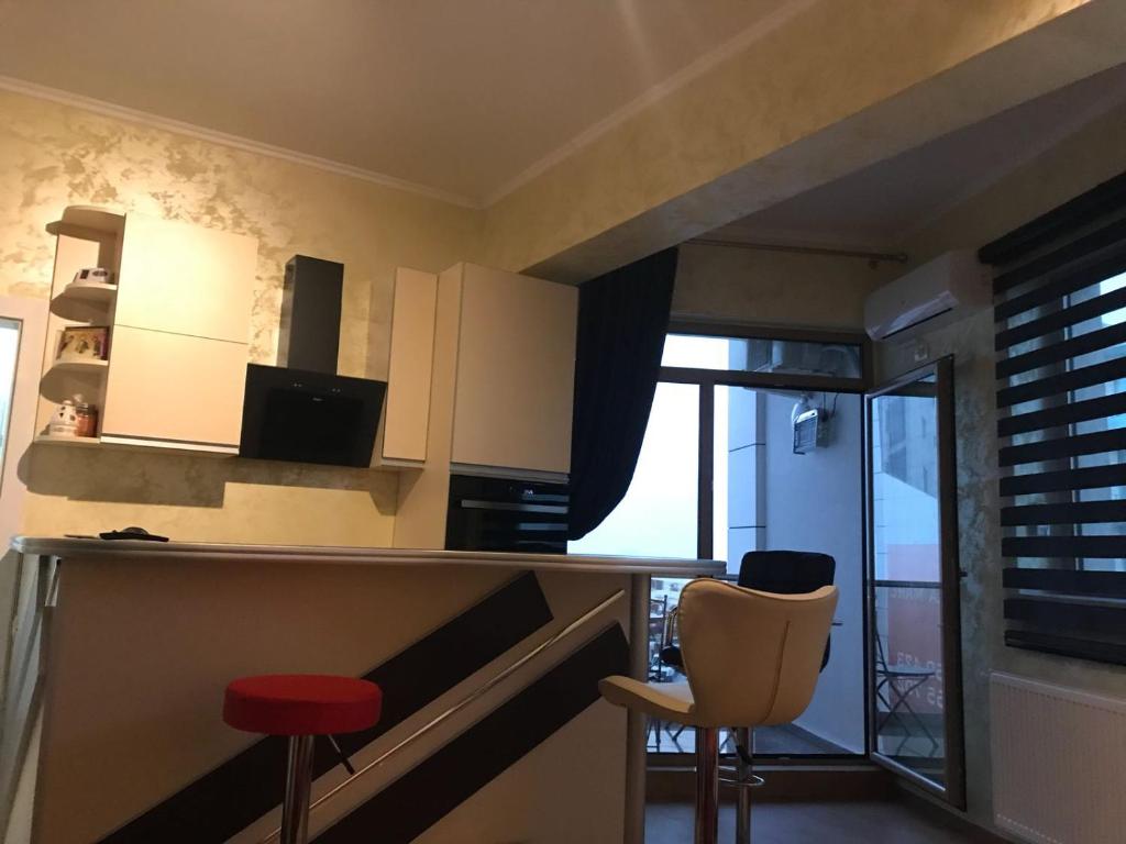 eine Küche mit einer Bar und zwei Hockern in einem Raum in der Unterkunft Apartament Loft Beach SummerlandRomania in Mamaia