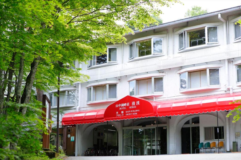 a building with a red awning in front of it at Yamanakako-Asahigaoka-Onsen Hotel Seikei in Yamanakako