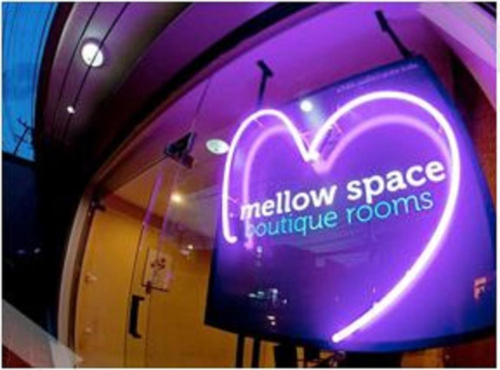 un signo cardíaco de neón en la ventana de una tienda en Mellow Space Boutique Rooms en Karon