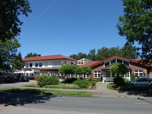 duży budynek z samochodem zaparkowanym przed nim w obiekcie Hotel-Landrestaurant Schnittker w mieście Delbrück