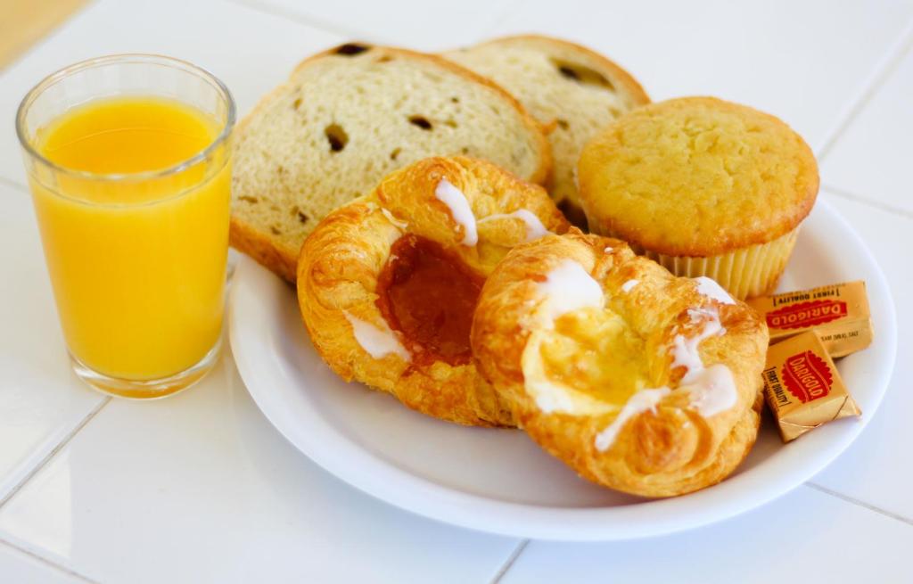 a plate of food with pastries and a glass of orange juice at Pea Soup Andersen's Inn in Buellton