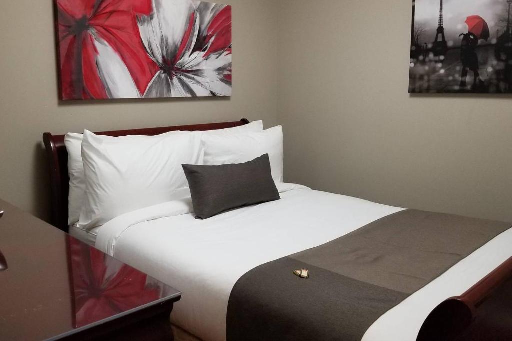 1 dormitorio con cama blanca y almohada negra en 2-Bedroom Apartment #30A by Amazing Property Rentals, en Gatineau