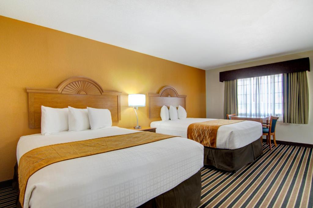 a hotel room with two beds and a window at Westbridge Inn & Suites in Clinton