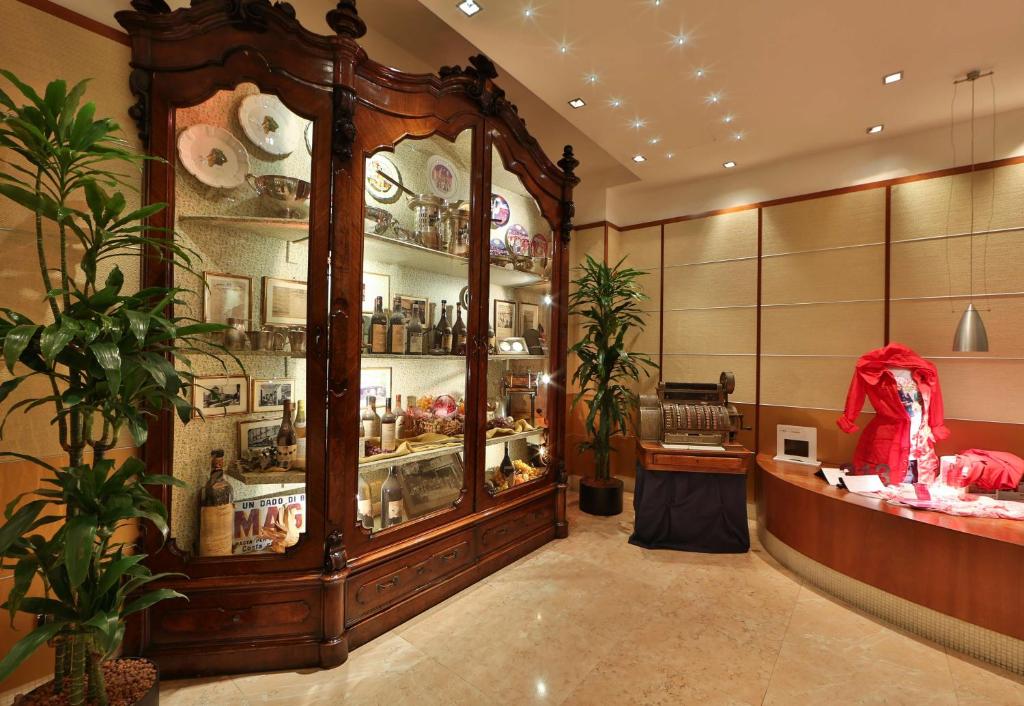 a shop with a large wooden display case in a room at Hotel Cappello D'Oro, BW Signature Collection in Bergamo