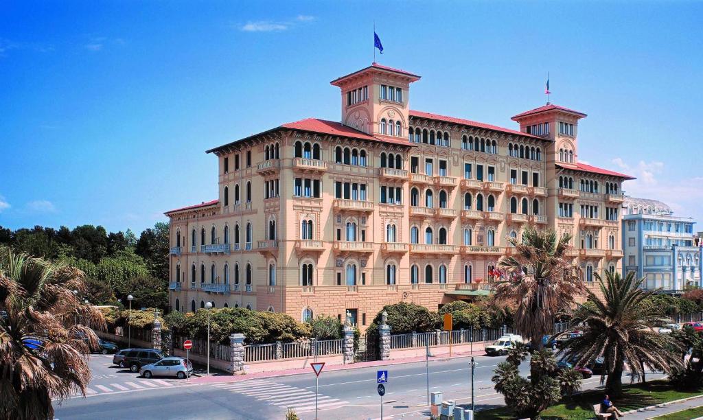 un grande edificio con una bandiera sopra di Grand Hotel Royal a Viareggio