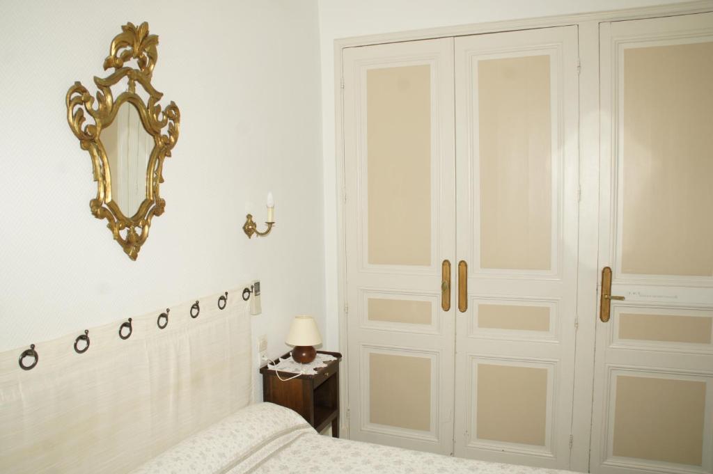 カルカソンヌにあるホテル モンセギュールのベッドルーム1室(ベッド1台、壁掛け鏡付)