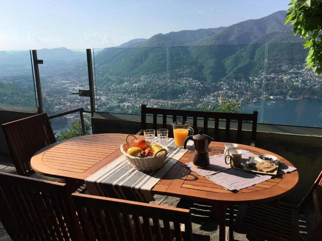 a wooden table with a bowl of fruit on a balcony at Baita Sorriso in Brunate